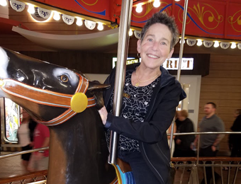 Jan Fisher riding a carousel horse on the Harmony of the Seas